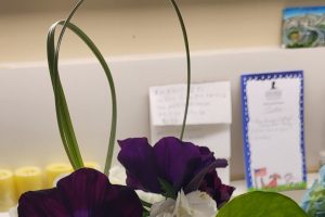 vase of purple and white flowers on desk