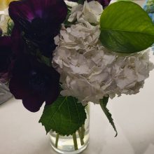 vase of purple and white flowers on desk
