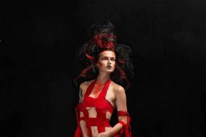 woman with red outfit and red and black hair