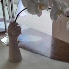 hand shaped vase holding orchids